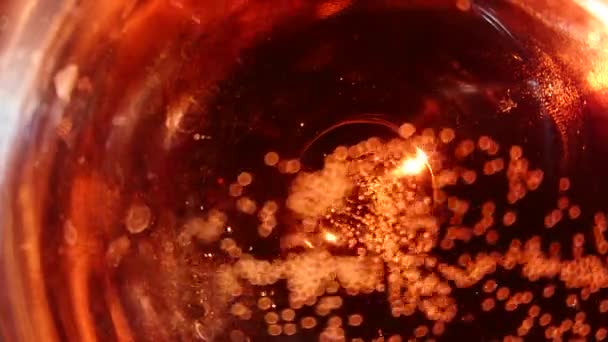 보케 효과와 붉은 액체에 상승 거품의 클로즈업 — 비디오