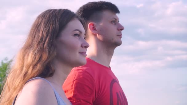 Primer plano, hermoso chico y chica están mirando hacia adelante, el uno al otro, abrazándose, sonriendo — Vídeos de Stock