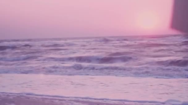 Surf delle onde, schiuma sullo sfondo di un'alba rosa, il sole — Video Stock