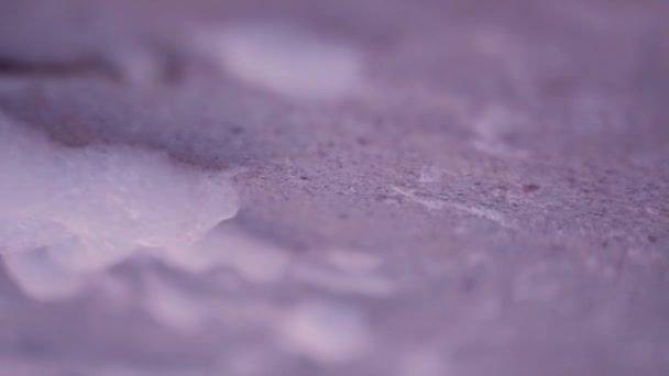 Пена от волн, качающихся на ветру по мокрому песку розового цвета морского берега — стоковое видео