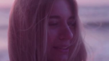 Close. Mavi gözlü sarı sarı saçlar rüzgarda gelişir. Deniz, arka planda dalgalar