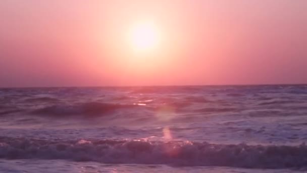 Beautiful sea with strong waves dark color against background orange, pink sky — Stock Video