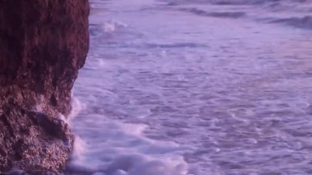 Grandes olas, con espuma de mar de color blanco, golpean contra la playa con arena mojada, roca arcillosa, contra un cielo azul — Vídeo de stock