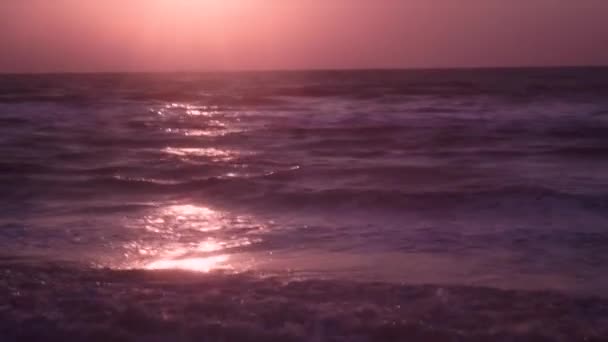 Hermoso mar con fuertes olas de color oscuro sobre fondo naranja, cielo rosa — Vídeo de stock