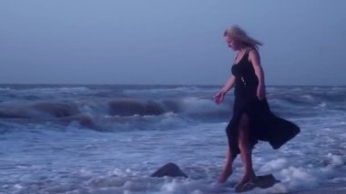 Kadın, bir bacak üzerinde bir taş üzerinde ayakta, deniz, Falls, gülüyor onun dengesini tutmaya çalışır