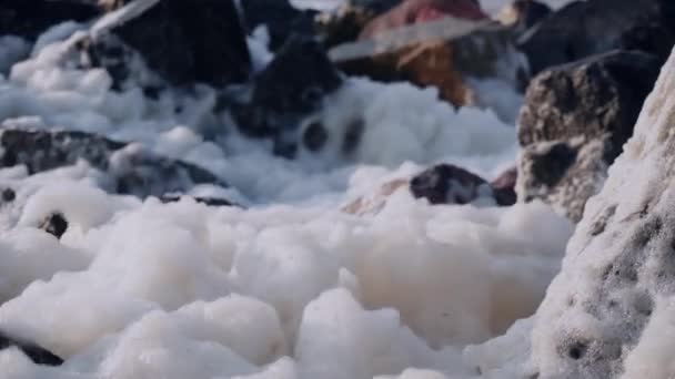 海中黑石上消压泡沫的特写 — 图库视频影像