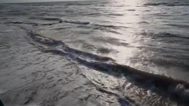 Mer de gris, en été, par temps venteux, force les vagues, la mousse formée sur le rivage, et le surf. Chemin solaire, horizon, ciel bleu, plage de sable — Video