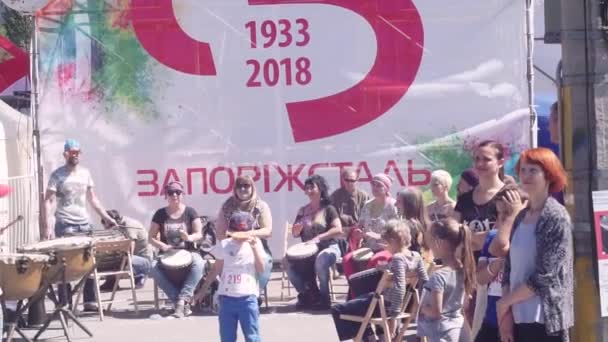 ZAPORIZHZHIA, UKRAINE - 29 AVRIL 2018 : typiquement, beaux jeunes gars, barbus hommes debout jouer sur le Cosaque, tambours militaires, tulumbas, avec des femmes dans un djembé en holi peinture sur la rue, à — Video