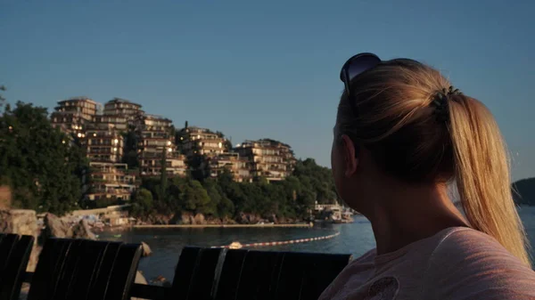 Linda menina olha para um hotel, em uma ilha, à noite, Dukli em Budva, Montenegro — Fotografia de Stock