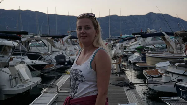Um turista fica em um cais, entre duas fileiras de barcos. Montenegro Budva — Fotografia de Stock