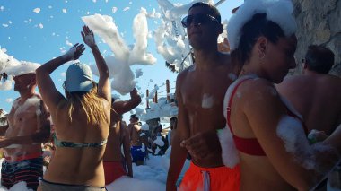 Budva, Karadağ - 23 Ağustos 2019: Havuzda elinde köpükle dans eden kız, öğleden sonra bir partide bar