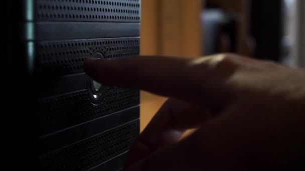 Hand, vinger, drukt op de knop van het systeem eenheid, computer op de achtergrond van de tafel — Stockvideo