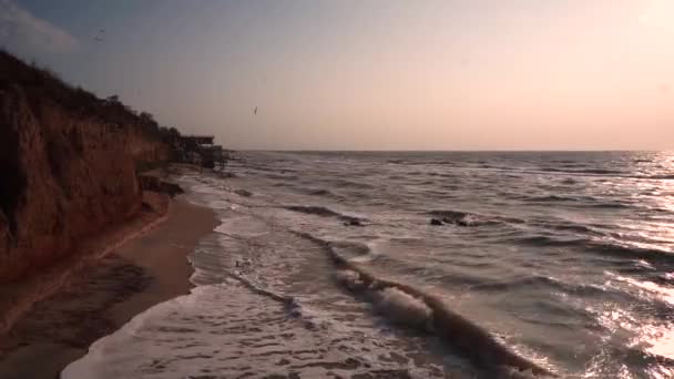Lila och rosa solnedgång utsikt över stranden med sandig lera brott och långsam slutartid havsvågor och klippor havsutsikt med brott zen scen på stranden — Stockvideo