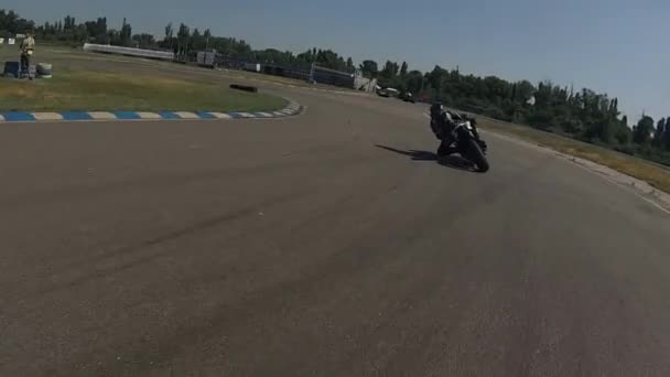 ЗАПОРИЖИЯ, УКРАИНА - 17 июня 2019 года: черный мотоциклист на велосипедной дорожке поворачивает в круг . — стоковое видео