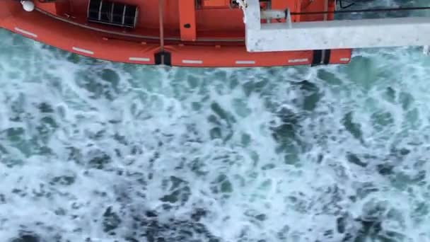 Orange bateau passe devant bleu, froid, belle eau, vue sur le dessus — Video