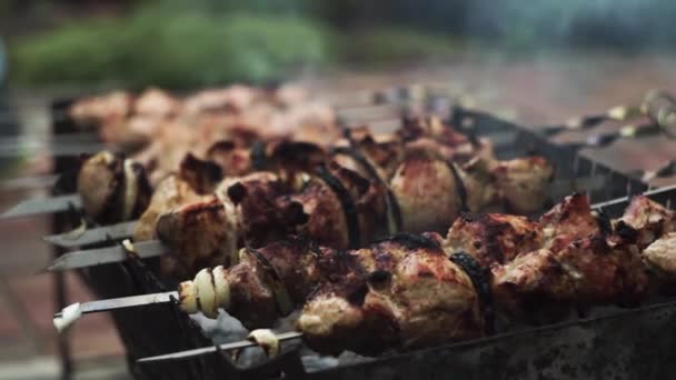 Os espetos de porco fritam-se em espetos em um churrasco em uma residência de verão, no verão — Vídeo de Stock