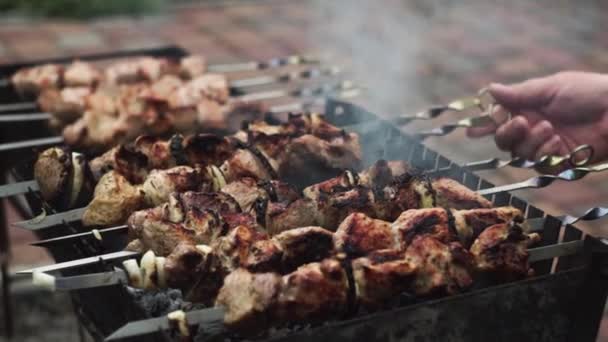 Mão torce espeto com carne para grelhar uniforme no país — Vídeo de Stock