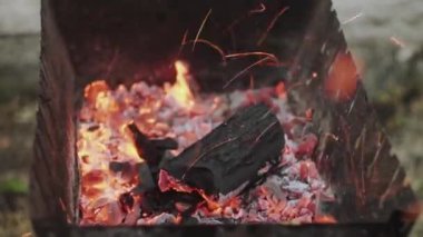 Mangal ızgarasında kömür yakmak. Kömür yanmaya başlar. Kıvılcımlar uçuşuyor