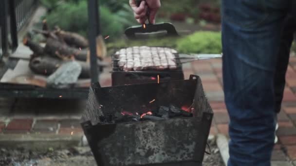 Close-up van het verbranden van houtskool in een barbecue grill. Steenkool begint te branden. Vonken vliegen weg. — Stockvideo