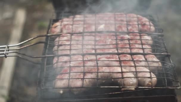 Saucisses grillées frites et fumées dans des grillades au charbon de bois. Saucisses en coquille naturelle. — Video