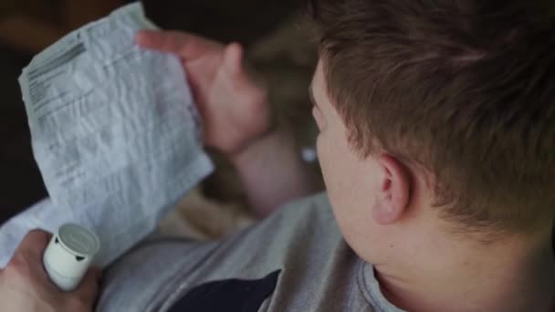 Mladý, nemocný, bledý chlap čte návod na tablety na venkově, léto — Stock video