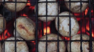 Aşçı ızgarada mantar hazırlar. Barbekü partisi. Lezzetli ızgara yemekler. Makro. Metal ızgarada kızartılmış mantar. Diyet vegan bbq.