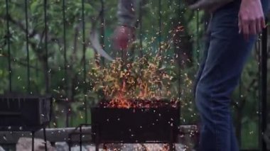 Kot pantolonlu bir adam yangından kıvılcımlar saçar, barbekü, kırsalda hava...