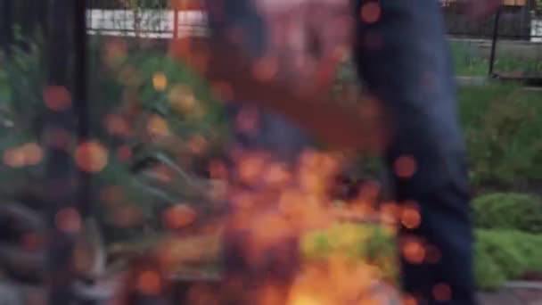 たき火から出て飛ぶ、国の青いジーンズの背景に火花のぼやけ — ストック動画