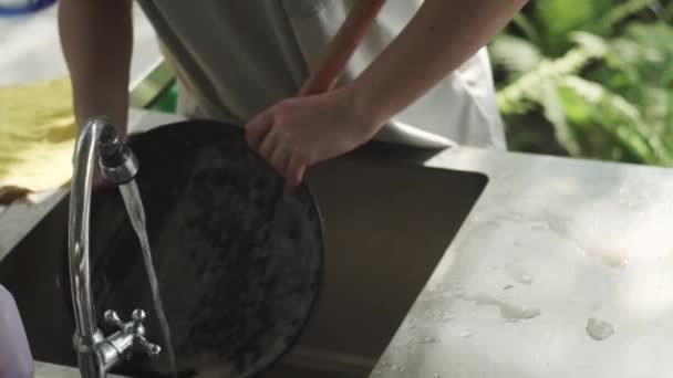 Frauenhände waschen Schaum aus Pfanne, unter fließendem Wasser, Metallwaschbecken, Küche, Ferienhaus — Stockvideo