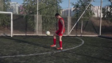 ZapOROZHYE, UKRAINE - 8 Temmuz 2020: kırmızı üniformalı adam topa vuruyor. Mini futbol sahasında