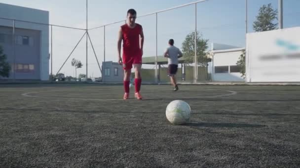 ZAPOROZHYE, UCRÂNIA - JULHO 8, 2020: Visão inferior em câmera lenta Jovem jogador de futebol ágil corre e chuta bola a pé no grande estádio moderno — Vídeo de Stock