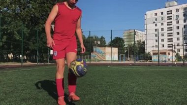 ZapOROZHYE, UKRAINE - 8 Temmuz 2020: kırmızı üniformalı adam topa vuruyor. Bahçedeki mini futbol sahasında.