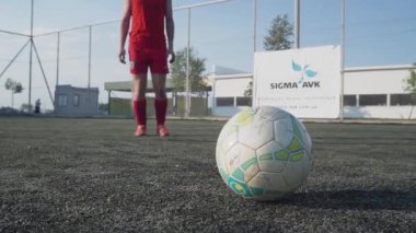 ZapOROZHYE, UKRAINE - 8 Temmuz 2020: Adam topa vuruyor. Koşuda, mini futbol sahasında. Kırmızı spor üniformalı. Yakın plan.