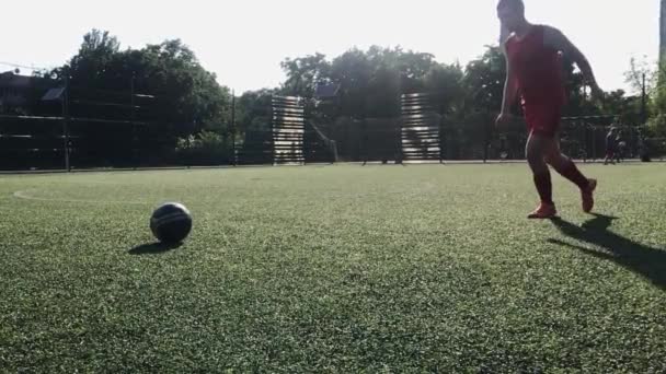 ZAPOROZHYE, UKRAINE - 8 JULI 2020: een man in een rood uniform met een run trapt de bal, op een mini-voetbalveld, training — Stockvideo