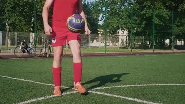 ZAPOROZHYE, UKRAINE - JULY 8, 2020: 붉은 유니폼을 입은 남자가 공을 차고 있다. 마당에 있는 축구장에서 — 비디오