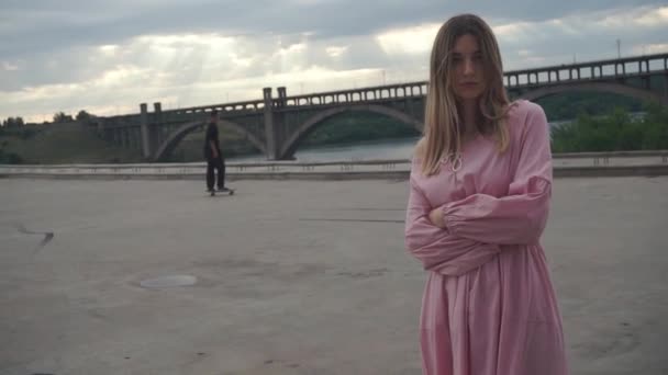 Stilvolles Mädchen in einem langen Kleid zwischen Skatern und U-Bahn-Standorten in der Stadt, urban — Stockvideo