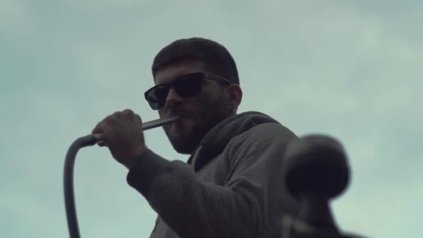 Stylischer Typ mit Sonnenbrille und Bart raucht Wasserpfeife auf weißem Hintergrund — Stockvideo