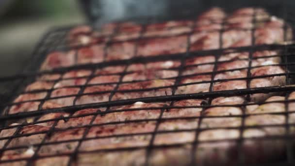 Salsichas grelhadas fritas e fumadas em grelhadores a carvão. Enchidos com casca natural. — Vídeo de Stock
