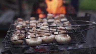 Aşçı ızgarada mantar hazırlar. Barbekü partisi. Lezzetli ızgara yemekler. Makro. Metal ızgarada kızartılmış mantar. Diyet vegan bbq.
