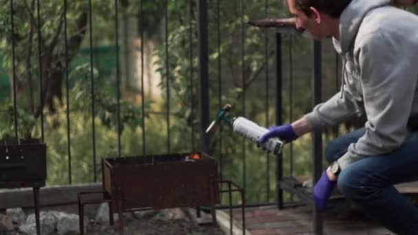Homme allume barbecue avec un brûleur à gaz — Video