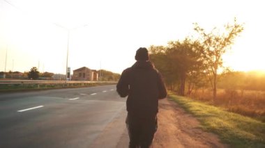 ZAPOROZHYA, UKRAINE - ECTOBER 04, 2020: maraton orta yaşlı, otomobil, asfalt yol gün doğumu boyunca koşar