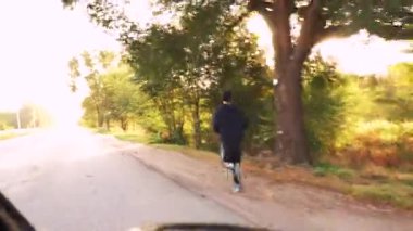 Araba yarışçısının ön camından ateş ediyor.