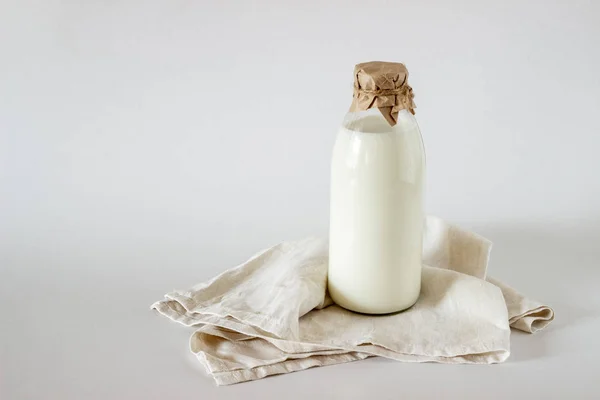 Uma garrafa de leite sobre um fundo branco — Fotografia de Stock