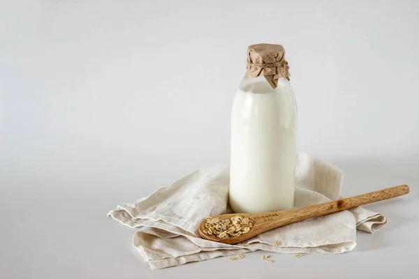 Eine Flasche Milch und einen Esslöffel Hafer. weißer Hintergrund — Stockfoto