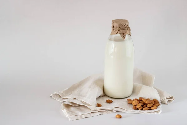 Milch und Mandeln auf weißem Hintergrund — Stockfoto