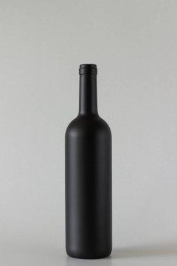 Gri arka planda siyah şarap şişesi.