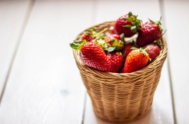 Ahşap bir arka plan üzerinde bir kase çilek. Sağlıklı beslenme.