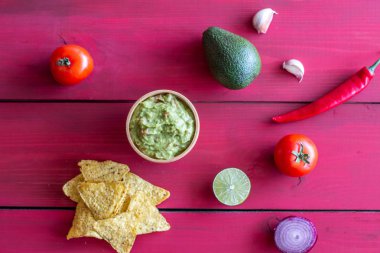 Guacamole ve cips nachos. Kırmızı arka plan. Meksika mutfağı.