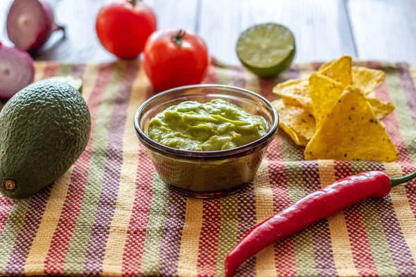 Guacamole en chips nacho's in het gekleurde servet. Mexicaanse keuken. — Stockfoto