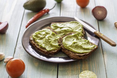 Mavi ahşap arka plan üzerinde avokado ile Sandviçler.